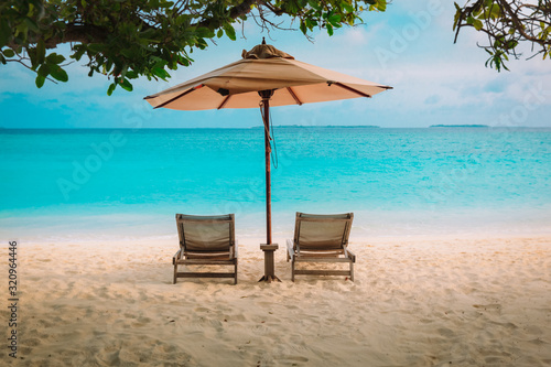 Fototapeta Naklejka Na Ścianę i Meble -  Two beach chairs on tropical sea vacation
