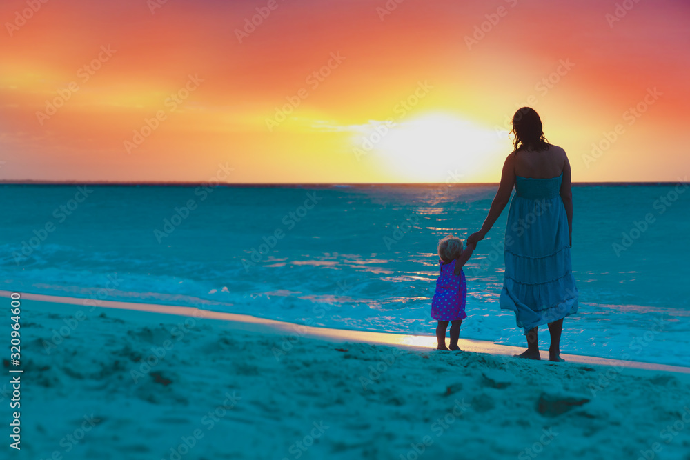 Fototapeta premium mother and little daughter enjoy sunset on beach