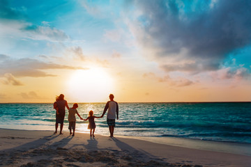 happy family with tree kids walk at sunset beach