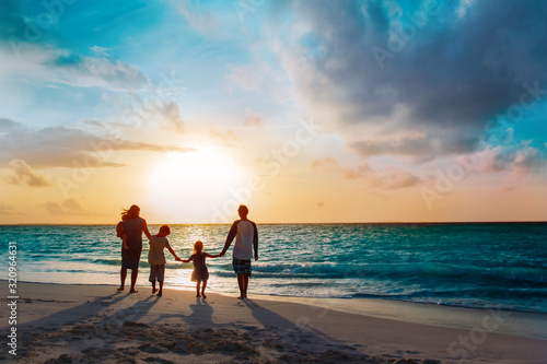 happy family with tree kids walk at sunset beach photo