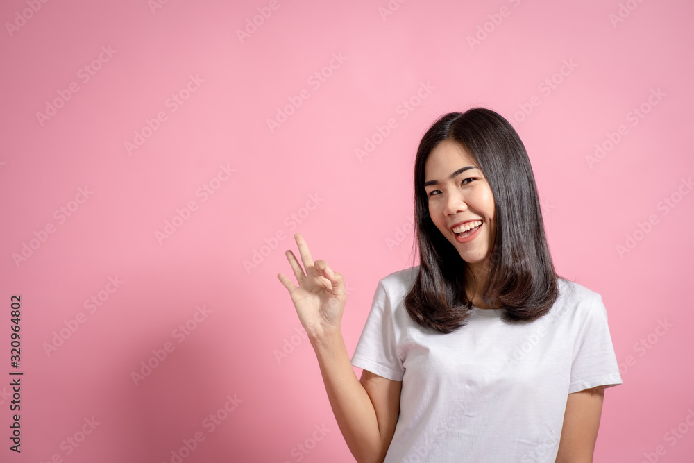 Portrait of a happy girl showing a gesture on a pink background Portrait of a happy girl showing a gesture on a pink background