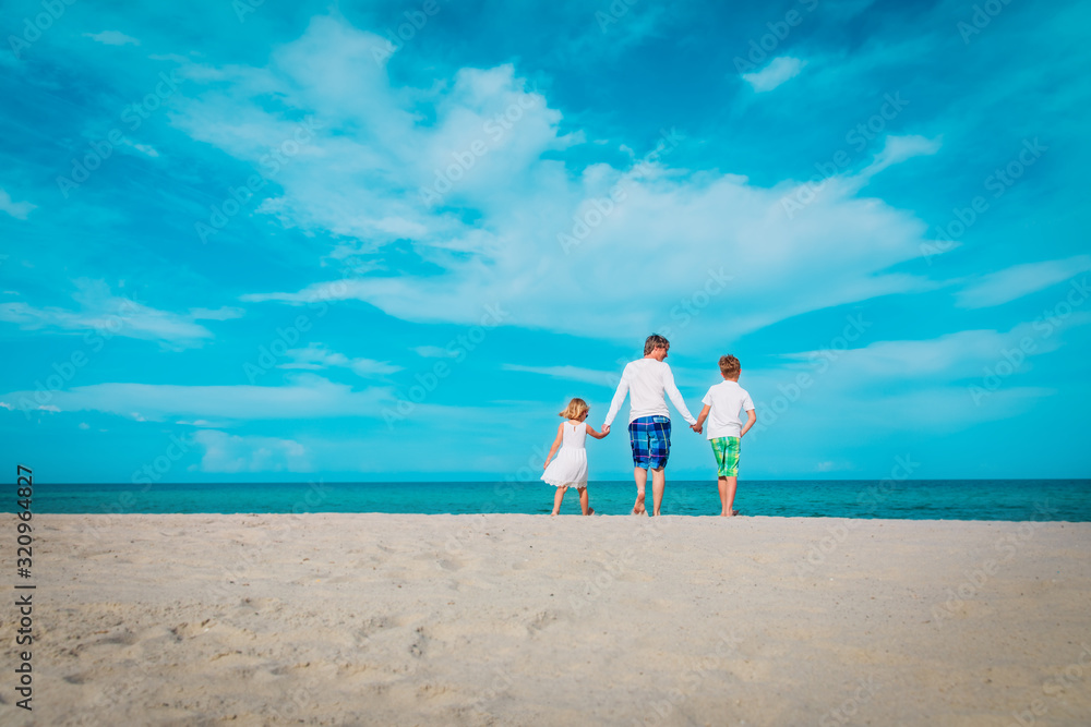 father with son and daugther walking on beach father with son and daugther walking on beach