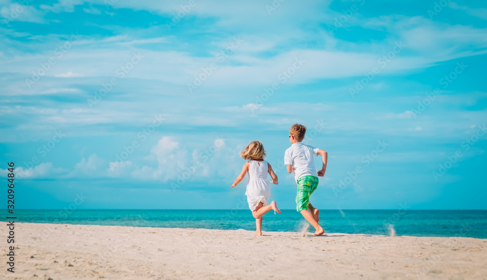 happy little boy and girl running on beach