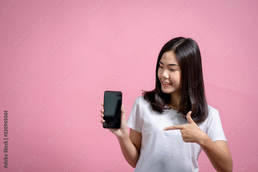 A very happy little girl with a mobile phone Photos of Asian girls wearing casual wear on pink backgrounds. Delightful emotions and concepts A very happy little girl with a mobile phone Photos of Asian girls wearing casual wear on pink backgrounds. Delightful emotions and concepts