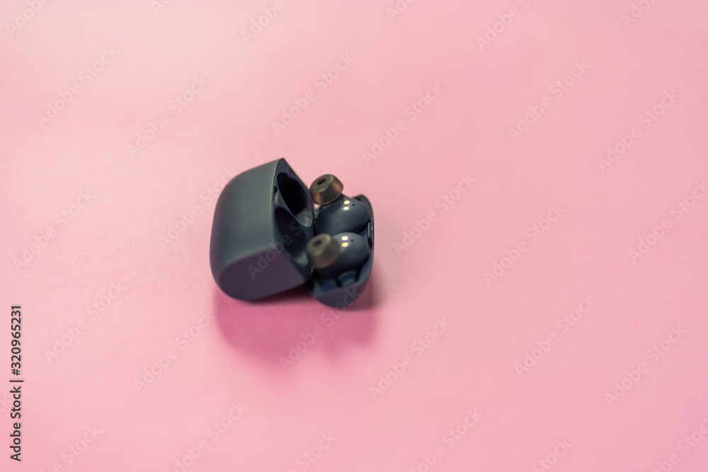 Wireless headphones on pink table with background Wireless headphones on pink table with background