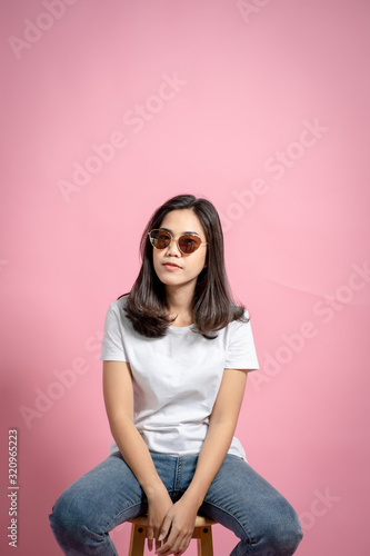 Fashion photos of beautiful girls in beautiful dresses with t-shirts resting above the pink background. Fashion images