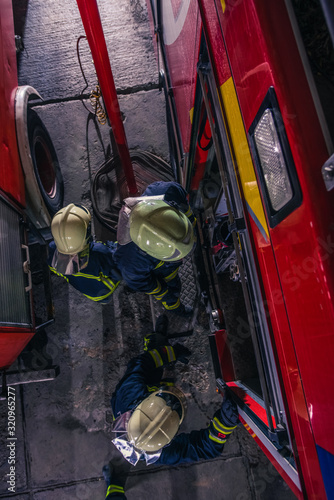 Firemen checking the fire engine inside the fire department from a bird perspective