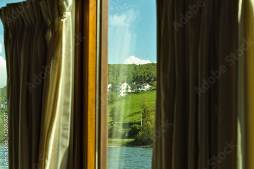 View of a german landscape through the glass of a window with curtains  Germany  Europe 
