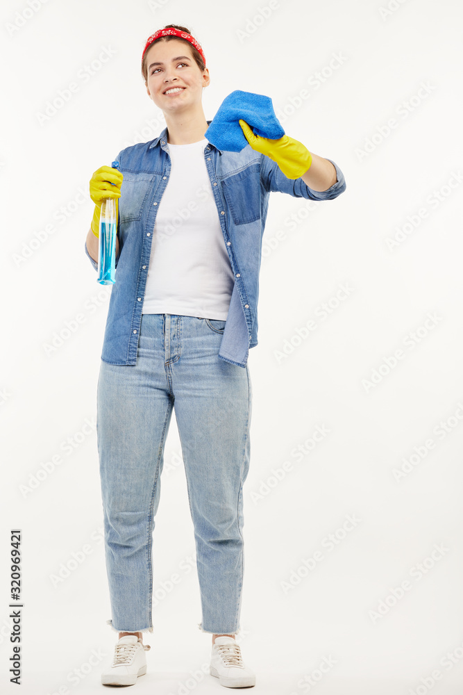 Pretty woman in work-wear shows how to clean windows.