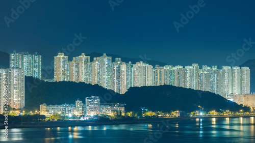 Night scene of high rise residential buildings and harbor of Hong Kong city