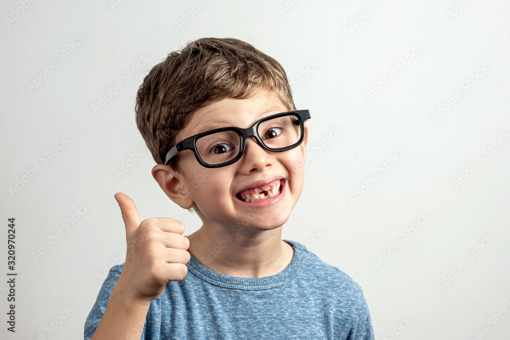 Handsome smiling toothless boy with large eyeglasses thumbs up