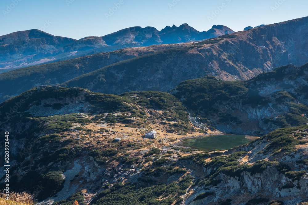 Mountain ridges, lake and refuge near its shore. Panoramic mountain landscape from Rila National Park from the circus of the Seven Rila Lakes, Bulgaria.