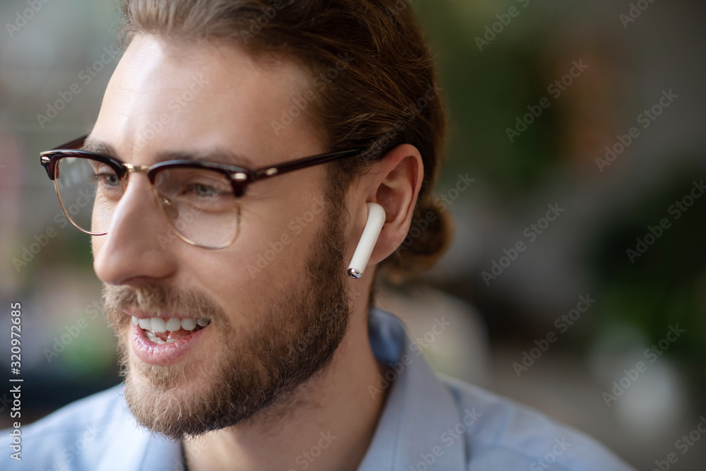 Happy face of man in glasses and in one wireless earpiece. Happy face of man in glasses and in one wireless earpiece.