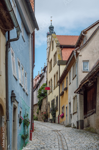 View of a narrow street with traditional colorful houses in the old medieval town of Rothenburg ob der Tauber, part of the Romantic Road in Germany, region Franconia, Bavaria. 
