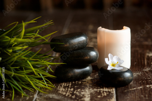 Massage stones and candle close-up on a wooden dark background