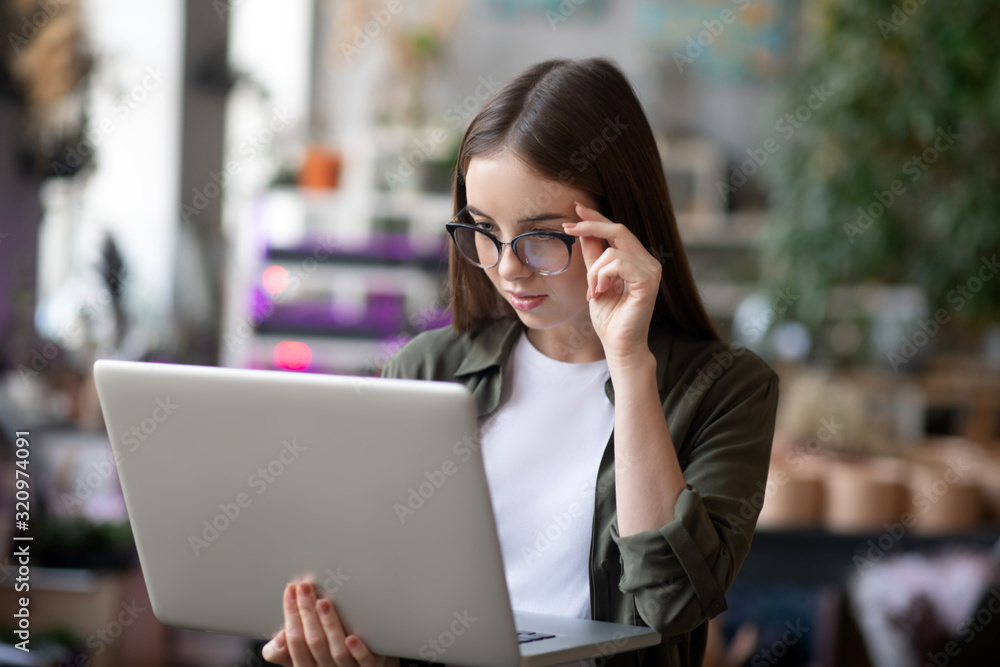 Girl in surprise looking at laptop screen holding it in hand. Girl in surprise looking at laptop screen holding it in hand.
