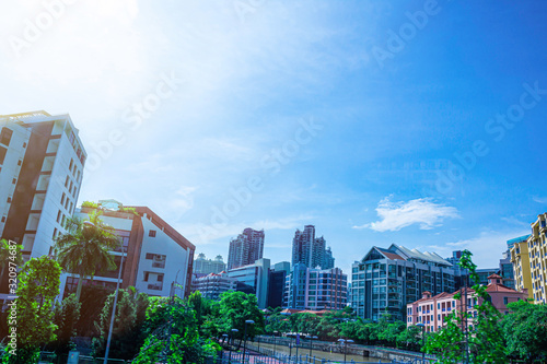 Top view of modern building with bright sky clouds, City scape background, Skyscraper with green tree background, Singapore city
