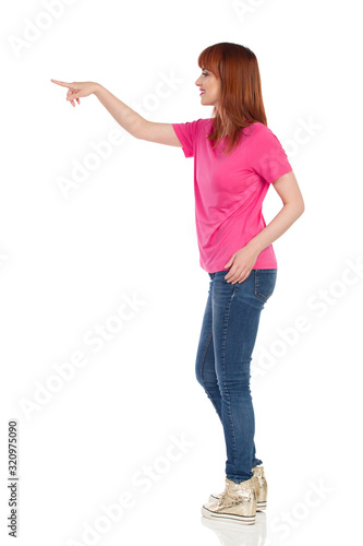 Young Woman Is Standing And Touching Something With Finger