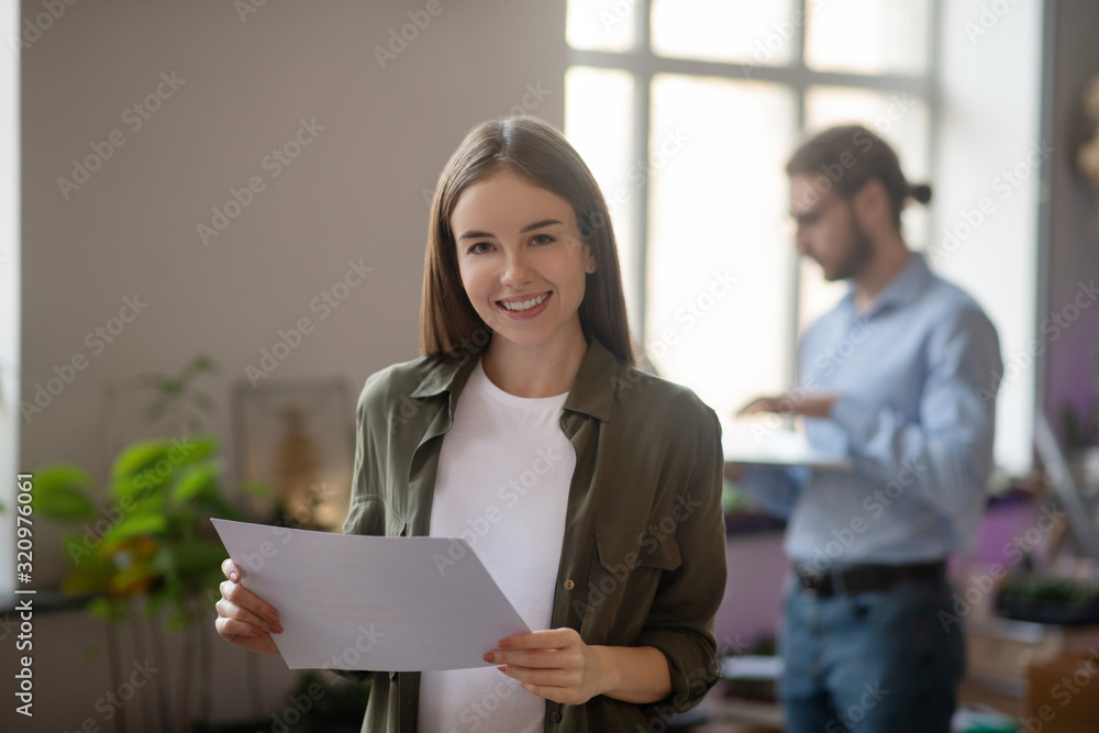 Nice joyful girl with a document in her hands. Nice joyful girl with a document in her hands.