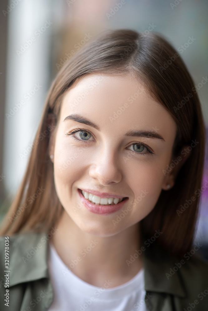 Cheerful and confident young woman smiling kindly Cheerful and confident young woman smiling kindly
