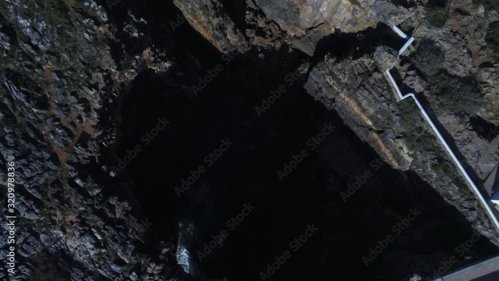 The amazing Boca do Inferno in the Cascais Municipality, Portugal with seawater rolling below - top view The amazing Boca do Inferno in the Cascais Municipality, Portugal with seawater rolling below - top view