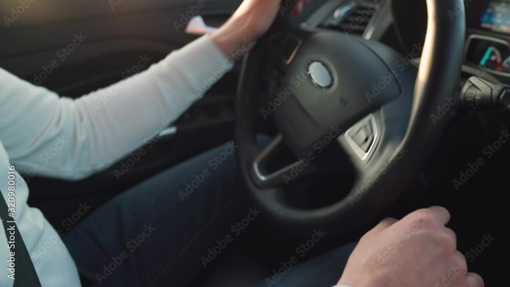 Close up of a man steers a car. Sunlight shines through the side window. Close up of a man steers a car. Sunlight shines through the side window.