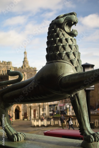 Close up focus of bronze lion statues at the entrance of Norwich City Hall, Norfolk, England, UK. Norwich Guildhall out of focus in background.