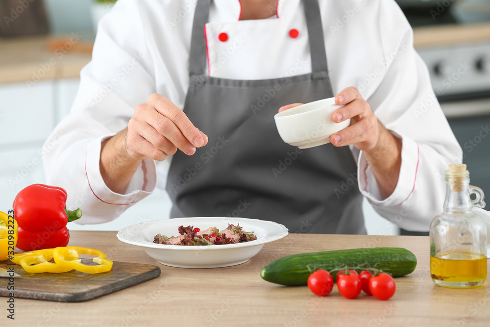 Male chef cooking in kitchen, closeup Male chef cooking in kitchen, closeup