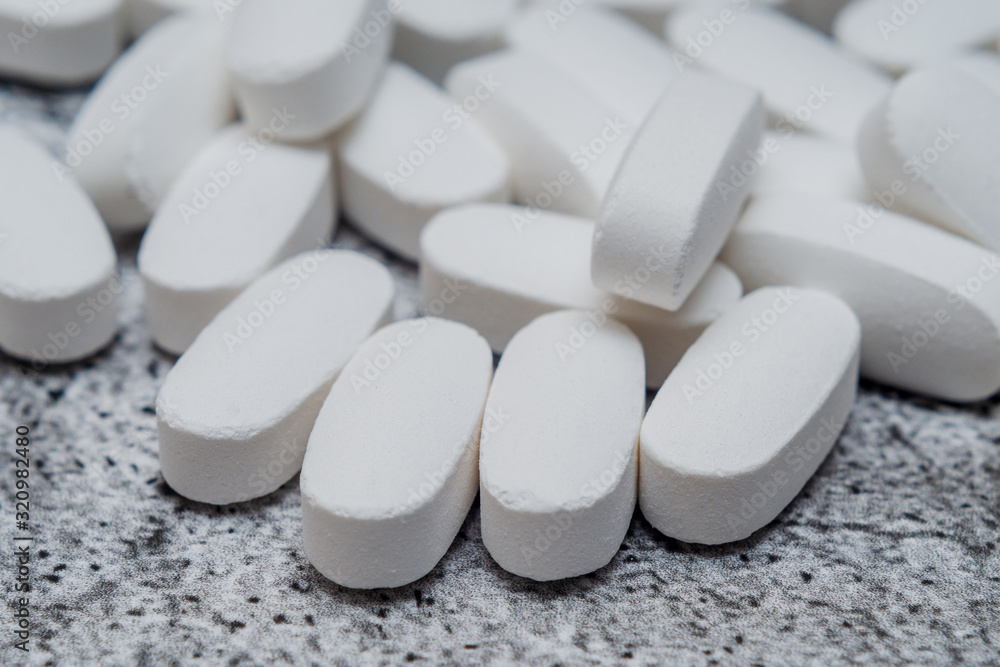 creatine pills in white close-up on a gray background creatine pills in white close-up on a gray background