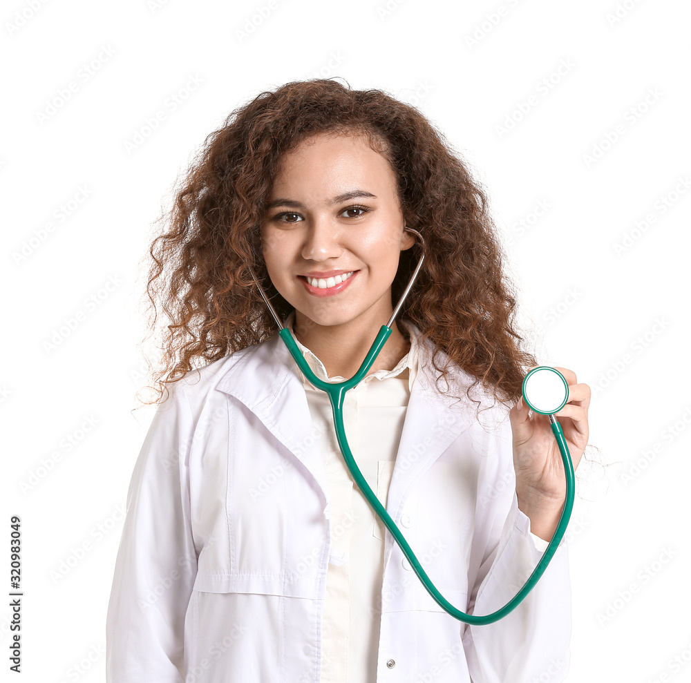 Young African-American doctor with stethoscope on white background