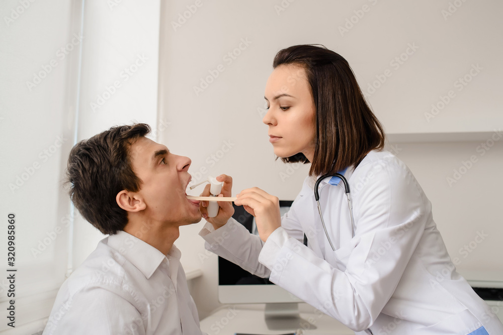 Young woman doctor otolaryngologist examine patient larynx and oral cavity Young woman doctor otolaryngologist examine patient larynx and oral cavity