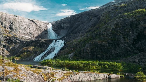 Kinsarvik, Hordaland, Norway. Waterfall Nykkjesoyfossen In Hardangervidda Mountain Plateau. Spring Sunny Day. Height Of 49 m. Famous Norwegian Landmark And Popular Destination. 4K photo