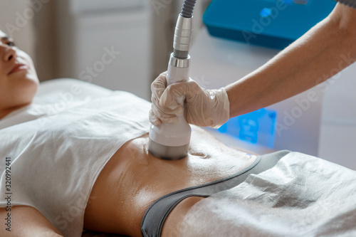 Hardware cosmetology. Body care. Spa treatment. Ultrasound cavitation body contouring treatment. Woman getting anti-cellulite and anti-fat therapy in beauty salon.