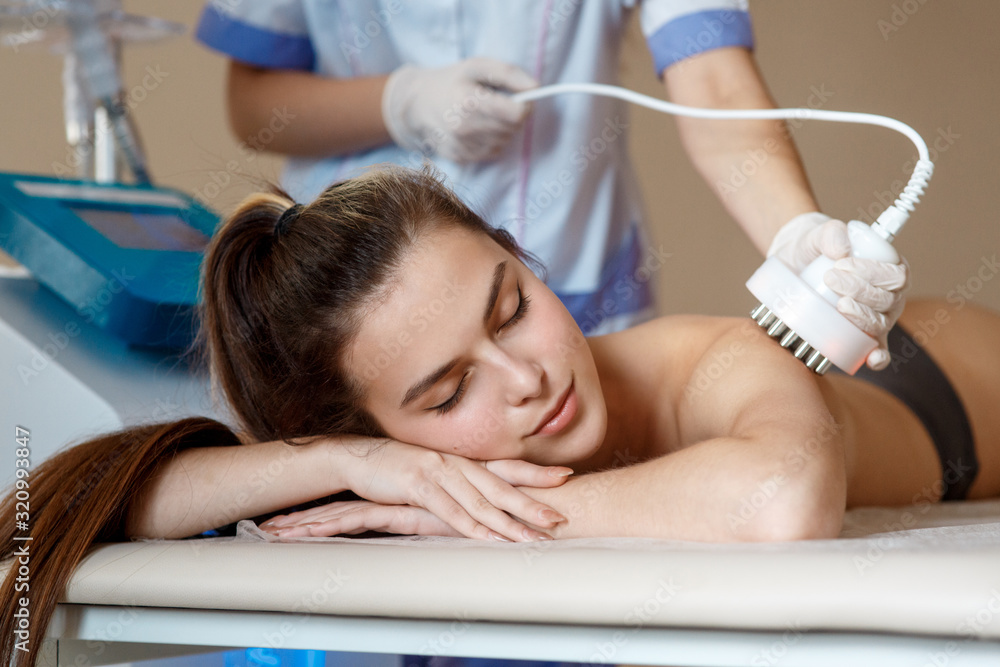 Hardware cosmetology. Picture of happy young woman with closed eyes getting rf lifting procedure in a beauty parlour. Hardware cosmetology. Picture of happy young woman with closed eyes getting rf lifting procedure in a beauty parlour.
