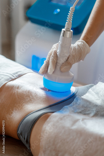Hardware cosmetology. Body care. Spa treatment. Ultrasound cavitation body contouring treatment. Woman getting anti-cellulite and anti-fat therapy in beauty salon.