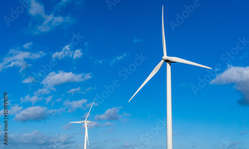 Two wind turbines set against a blue sky