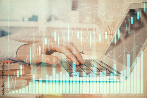 Double exposure of stock market graph with man working on laptop on background. Concept of financial analysis. © peshkova