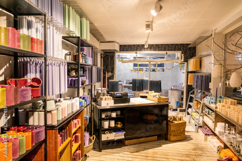 Natural beeswax candles production photo. Colorful candles on shelfs, process of candles making.