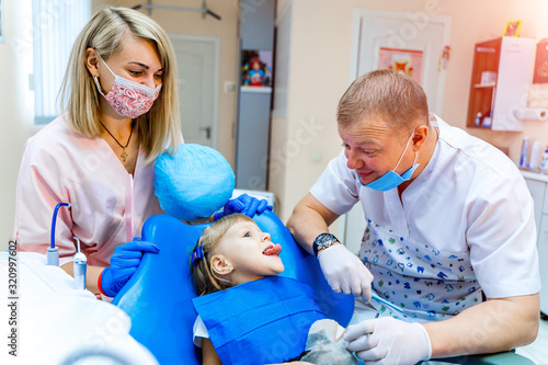 Dentist examining little girls teeth in clinic. Teeth care.