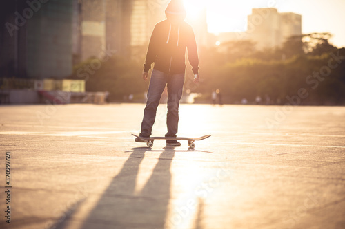 Photography Skateboarder skateboarding at sunset city