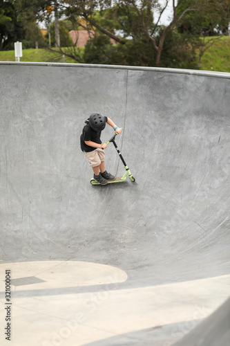 Young boy wearing skate helmet playing at the skate park in Portland, Victoria Australia