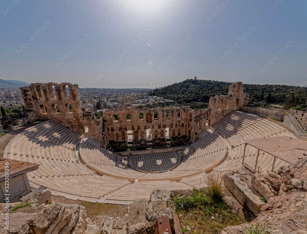 Greece, Herodium open odeon under Acropolis and Athens cityscape under hot burning sun with light lens flare