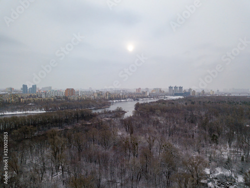 Aerial drone view. Snowy forest on a cloudy morning.