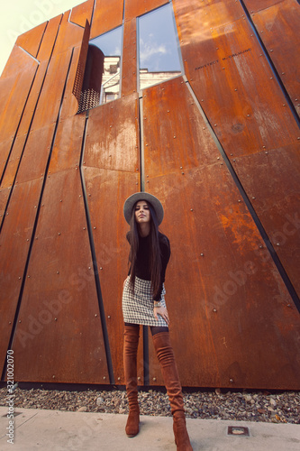 Beautiful girl model posing against the background of the modern building
