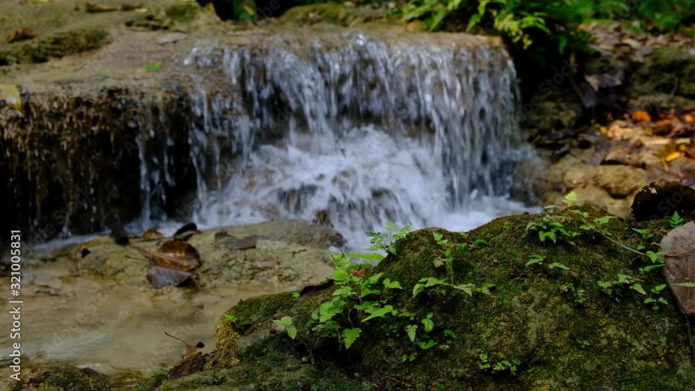 Closeup. The stream flows water with brown rocks. Closeup. The stream flows water with brown rocks.