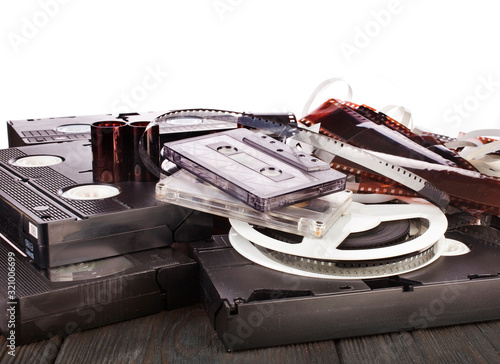 Vintage film camera rolls, old audio and video casettes with tape and foto strip isolated on a white background.