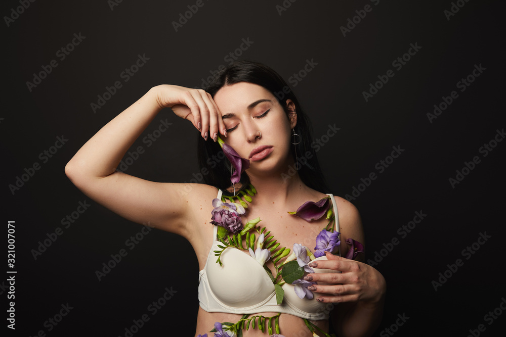 tender beautiful girl in bra with violet and purple flowers on body isolated on black tender beautiful girl in bra with violet and purple flowers on body isolated on black