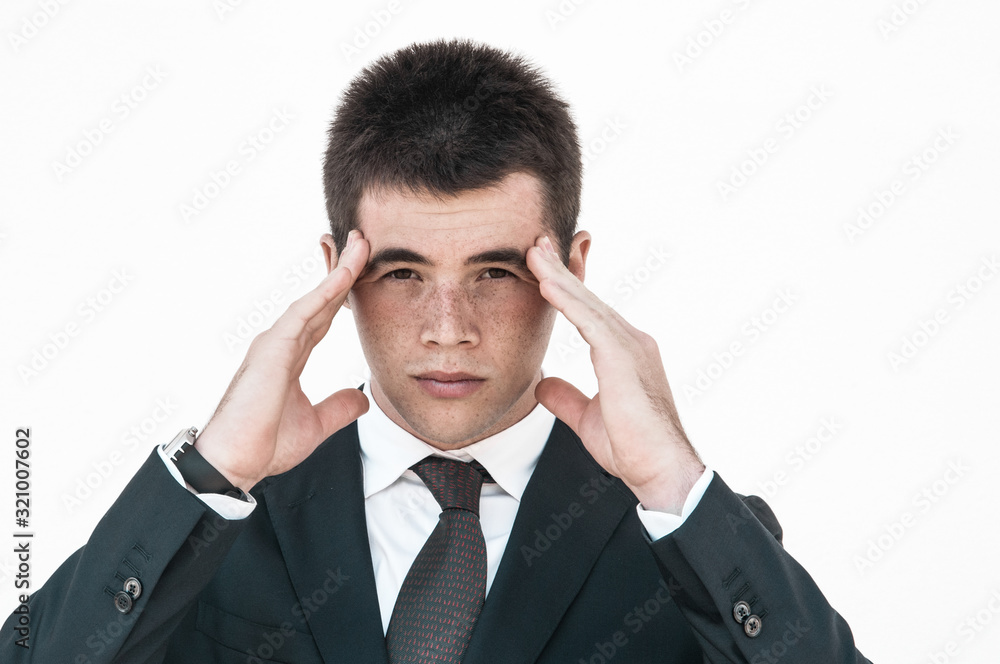 Tired pensive office employee suffering from head ache. Young man touching head and massaging temples. Headache concept Tired pensive office employee suffering from head ache. Young man touching head and massaging temples. Headache concept