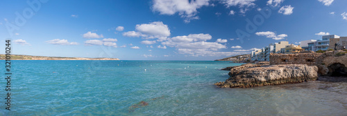 Panorama of landscape of Malta with turquoise clear water, coastline rock cliffs and residential houses