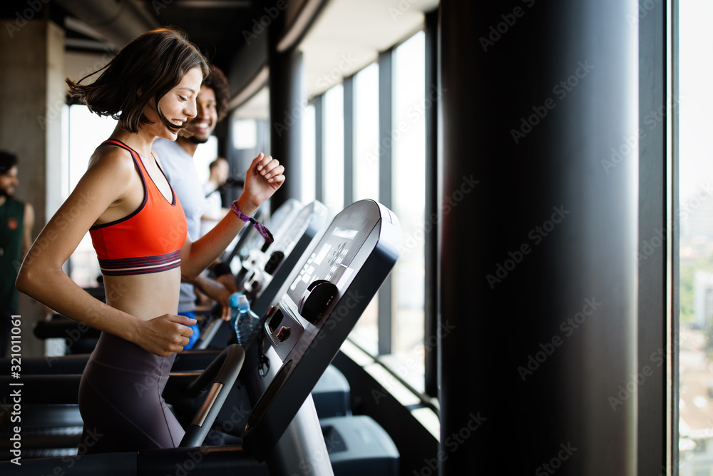 Fit group of people exercising on a treadmill in gym Fit group of people exercising on a treadmill in gym